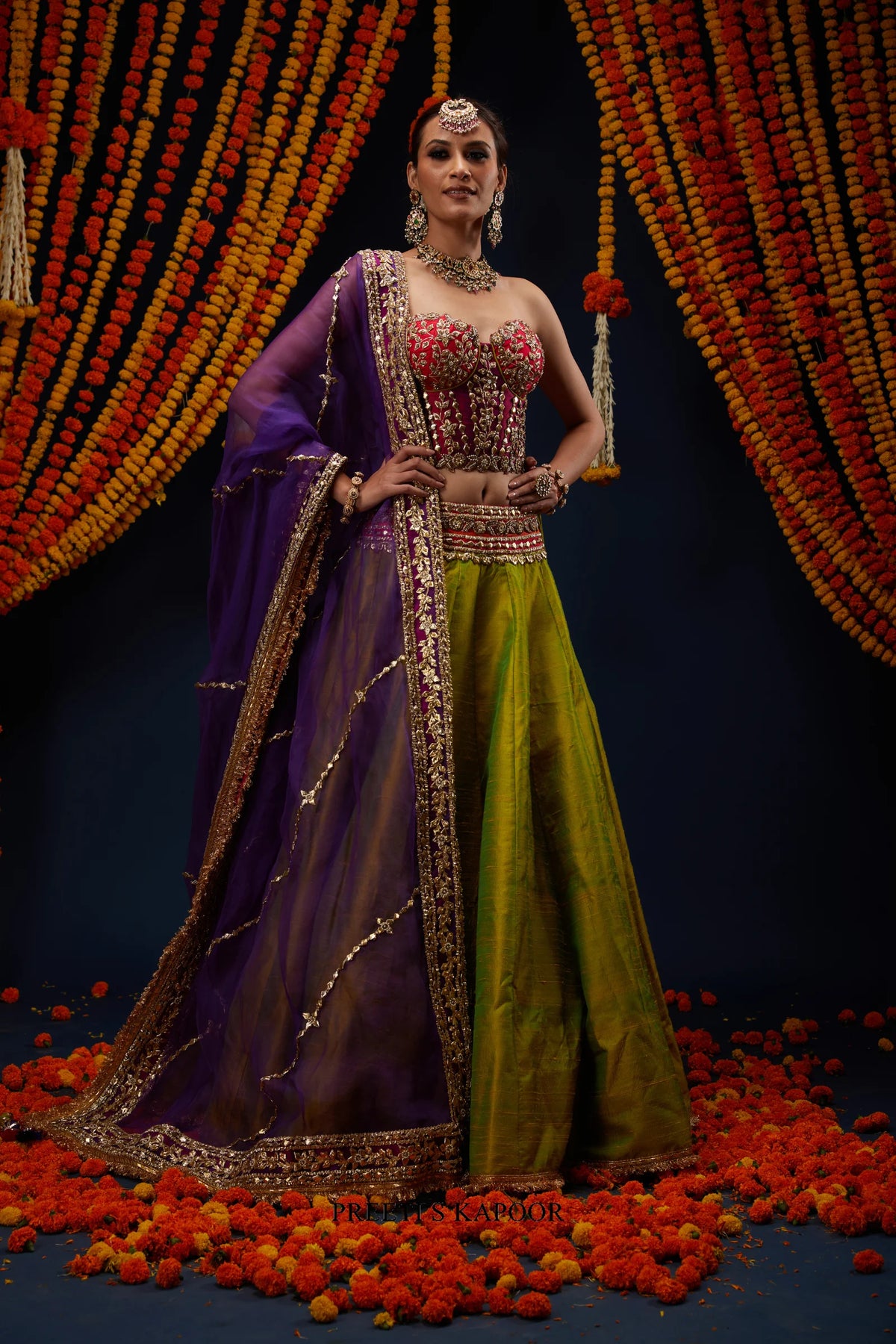 Woman wearing Mehendi Green raw silk lehenga with Fuchsia Pink bustier blouse and Purple dupatta – Preeti S Kapoor