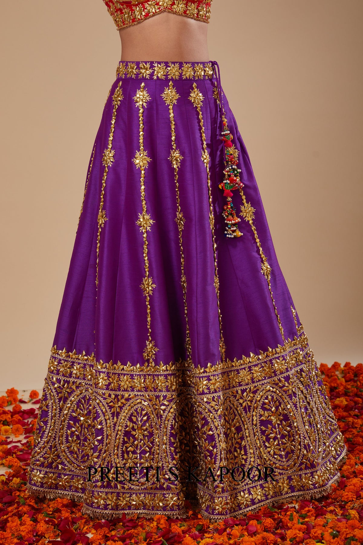 Purple embroidered lehenga with gold details on a floral background