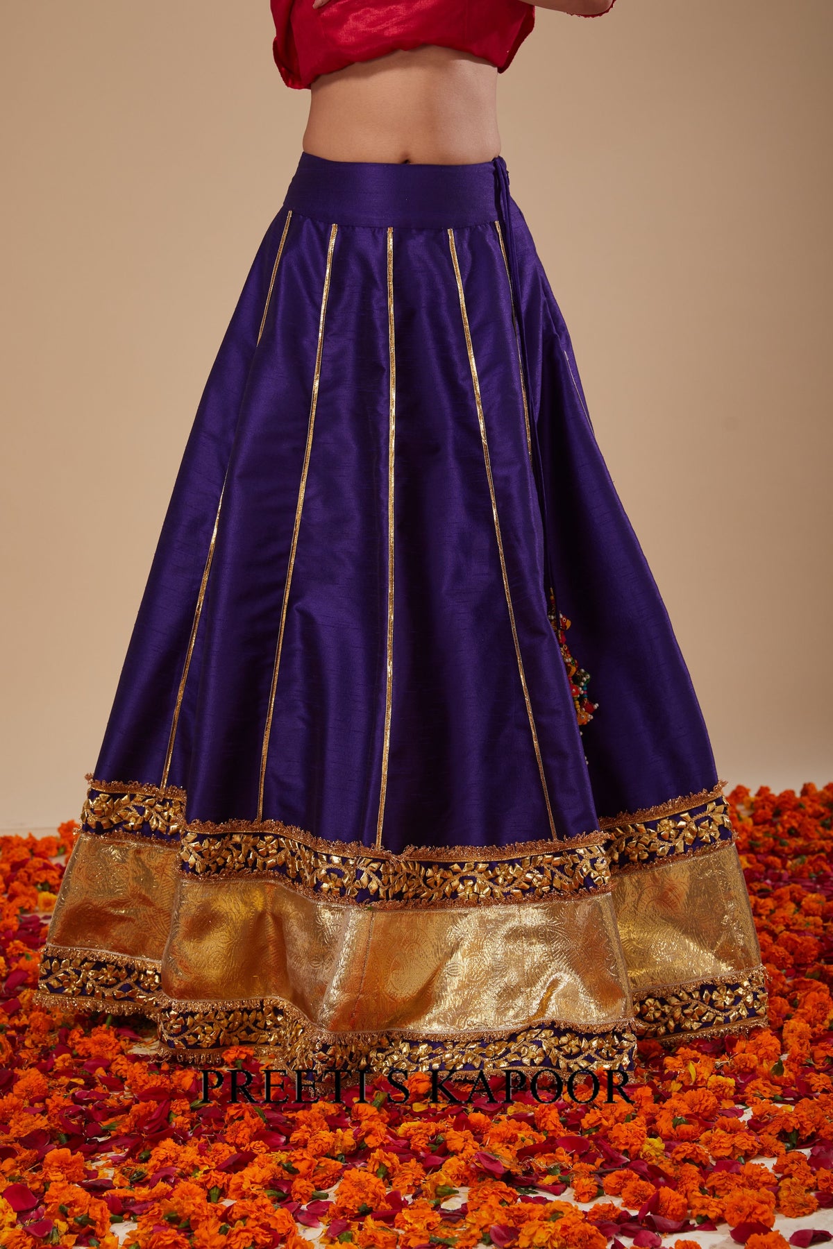 Purple and gold traditional skirt with intricate designs on a floral background