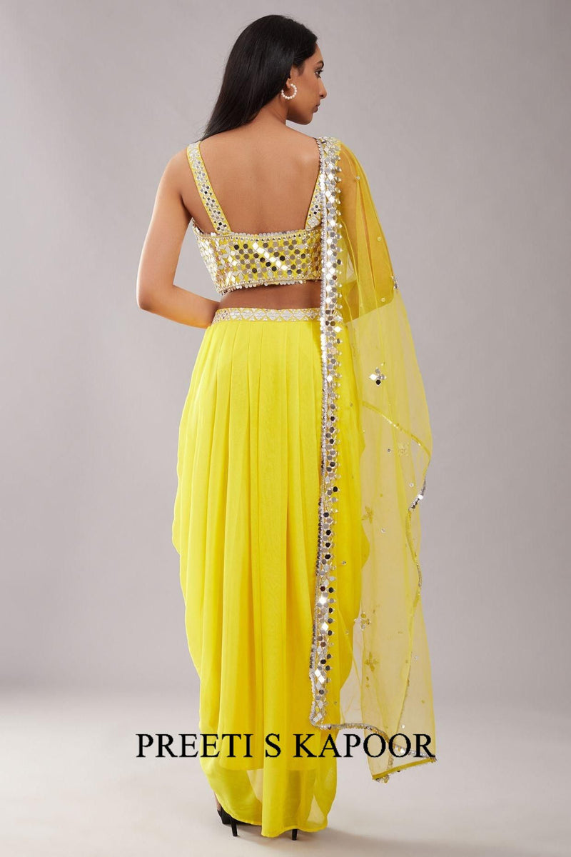 Yellow saree with a matching blouse on a gray background, featuring the brand 'Preeti S Kapoor'.